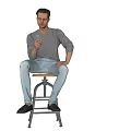 A Man Sitting On Stool Holding Phone Wearing Gray Long Sleeve Shirt And Light Pants