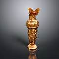 Golden Vase Shaped Sculpture With Intricate Carved Patterns And Wing Decorations