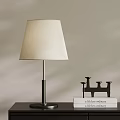 Modern Table Lamp With Metal Base And Fabric Shade Near Black Candlestick And Books