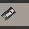Silver VHS Video Recorder With Classic VHS Tape Placed On Top Surface