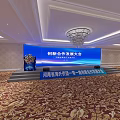 Large Conference Hall Setup With Long Tables White Chairs And Digital Screens