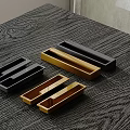 Stylish Modern Cabinet Handles In Black Gold Brown Metal On Wood Grain Tabletop