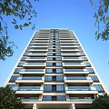 Tall Modern Residential Building With Multiple Floors Balconies And Blue Sky Background