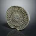 Ancient Circular Stone Carving Featuring Radiant Floral Patterns And Dots