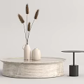Round Textured Stone Coffee Table with White Vase Dried Pampas Grass and Black Side Table