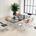 Modern Glass Top Conference Table With Colorful Chairs And Green Plant In Bright Office