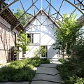 Serene Courtyard Garden With Red Brick Walls Glass Roof White Building And Stone Path