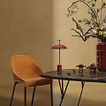 Orange Upholstered Dining Chair With Black Marble Table And Red Table Lamp