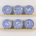 Blue Decorative Plates With Intricate Zodiac Designs Displayed On Wooden Shelves