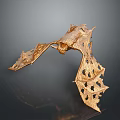 Golden Bat Sculpture Featuring Spread Wings and Intricate Hollow Patterns on Dark Background