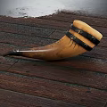 Natural Ox Horn Drinking Cup With Black Leather Straps On Wooden Floor
