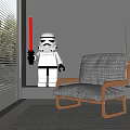 Light Gray Fabric Leisure Chair With Wooden Armrests And Lego Stormtrooper Holding Red Lightsaber
