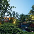Rockery Stones In Scenic Garden With Small Stream Lush Green Plants And Evening Lights