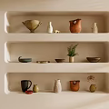 Various Ceramic Vessels Displayed on Built in Shelves with Beige Wall Potted Plant and Dried Flowers