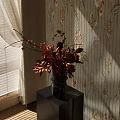 Black Vase With Orange Red Flowers On Pedestal Table Against Floral Striped Wallpaper
