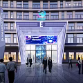 Modern Building Exterior Wall With Large Windows Geometric Archway Digital Screen Spacious Plaza And Greenery