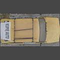 Vintage Yellow Car Covered With White Cloth Having KUPĘ AUTO Text And Roof Rack