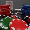 Colorful Poker Chips for Card Games Stacked and Scattered on Black Surface