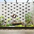 Garden Ornament Featuring Gray Wall Triangular Patterns Crane Sculptures Green Plants Water Feature and Pebbles