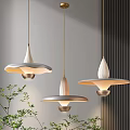 Three Modern Pendant Lights With Broad Brimmed Shades Golden Rods Gray White Tones And Green Plants