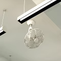 White Air Conditioning Fan Mounted on Ceiling with Hanging Strip Lights in Indoor Space