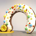 Dessert Shop Displaying Giant Ring Donut With White Frosting Colorful Candy Beans And Small Donuts