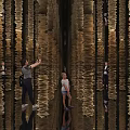 Art Installation With Tall Vertical Golden Paper Structures And Reflective Floor For Visitors