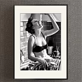 Vintage Black and White Female Portrait in Kitchen with Brick Wall Utensils and Countertop