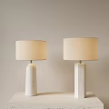 Two Modern Table Lamps With White Speckled Bases And Beige Lampshades On Light Table