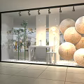 Stylish Window Showcase With Decorative Umbrellas Bamboo Plants And White Pebbles