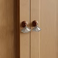 Elegant Fan Shaped Metal Handles On Wooden Cabinet Doors With Brown Accents