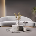 Gray Curved Sofa And Round Stone Coffee Table With Dried Flowers Woven Rug Green Plants