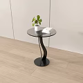 Round Glass Top Coffee Table With Black Curved Base Green Plant And Books On Light Wooden Floor