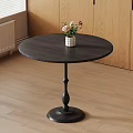 Round Black Dining Table With White Vase And Colorful Flowers On Wooden Floor