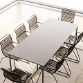 Modern Outdoor Table With Marble Top And Black Woven Chairs For Patio Area