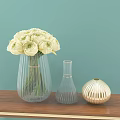 White Flowers in Transparent Vase with Small Golden Vase on Wooden Table Light Blue Background