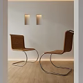 Wicker Leisure Chairs With Curved Metal Legs Against Light Wall And Wooden Floor