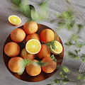 Fresh Ripe Oranges In A Bowl With Whole And Sliced Pieces And Green Leaves