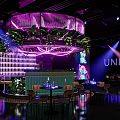 Modern Restaurant With Purple Lighting Circular Structure Green Plants Bar Counter And Wine Rack