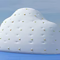 White Cloud Shaped Doll With Small Golden Dots On Blue Water And Sky Background