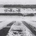 Snow Covered Ground Surface With Vehicle Tracks And Packed Snow Patches