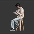 Man Sitting On Wooden Stool Holding Phone And Blue Cup In Light Sweater