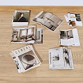 Open Interior Design Magazines With Home Photos Scattered On Wooden Floor