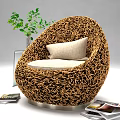 Woven Brown Round Leisure Chair with Light Colored Cushion Green Plant Transparent Vase and Magazines