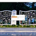 Modern Sculpture with Calligraphy on Screen like Structure Green Plants and Water Reflection