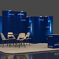 Blue Exhibition Booth With Display Panels Round Table White Chairs And Reception Desk