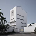 Sleek Modern White Residential Building with Large Windows Palm Trees Cacti and Driveway Surroundings
