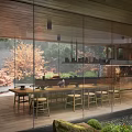 Modern Tea House With Glass Curtain Walls Surrounded by Green Trees and Wooden Tables Chairs