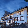 Modern Boutique Guesthouse Building With White Walls Large Glass Windows And Waterfront Wooden Fence