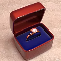 Elegant Red Jewelry Box With Blue Cushion Holding Pink Gemstone Ring